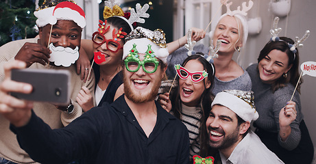 Image showing Christmas, party and friends taking a selfie on a phone together with goofy, funny and silly props. Diversity, festive and happy people taking picture on a smartphone at festive xmas event at a home.