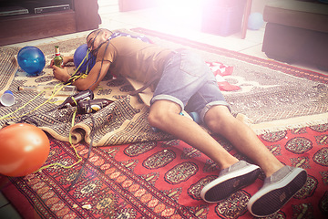 Image showing Party, drunk and hangover with a man sleeping on a living room floor after new year celebration. Beer, college and hungover with a male passed out after a frat house birthday event for spring break