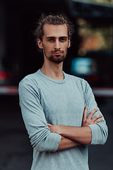 Image showing Portrait of a young successful businessman with crossed arms in front of the company