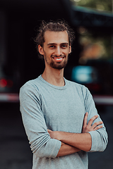 Image showing Portrait of a young successful businessman with crossed arms in front of the company