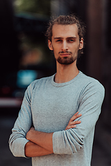 Image showing Portrait of a young successful businessman with crossed arms in front of the company