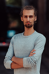 Image showing Portrait of a young successful businessman with crossed arms in front of the company