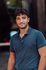 Image showing A portrait of a modern man, exuding confidence and style, against an outdoor backdrop, showcasing his charisma and fashionable demeanor.