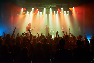 Image showing Rock, band and crowd of people at concert for stage performance, party dance and new year or holiday festival in dark. Dancing, singing and celebrity or musician with night club music for an audience