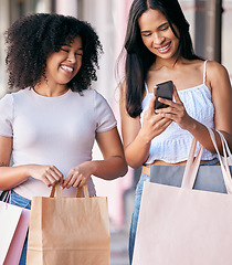 Image showing Woman, friends and phone with shopping bags, smile and enjoying free time or social media together in the city. Happy women smiling in happiness for online sale, deal or discount on mobile smartphone