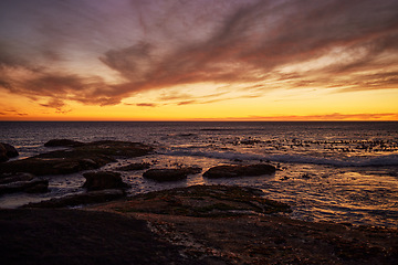 Image showing Sunset, beach and landscape of natural environment, ocean and sea during night in summer. Sky, nature earth and sunrise in horizon in a tropical, calm and location with peace in Thailand on an island