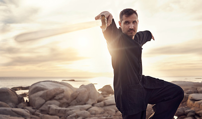 Image showing Man, sword and zen thai chi balance on beach for fitness training, chakra healing or spiritual energy. Thai wellness workout, meditation exercise and therapy with weapon for self defence at ocean