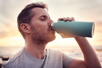 Image showing Man, fitness and water bottle with sunset beach background for thirst, hydration and healthy lifestyle while outdoor for exercise, workout and training. Male athlete drinking refreshment in nature