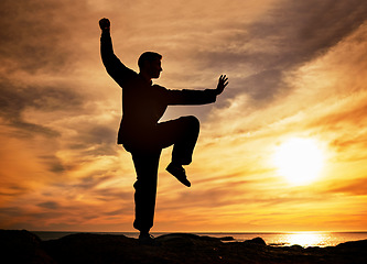 Image showing Sunset, beach and silhouette of man doing yoga for mind, body and spiritual wellness in the evening. Twilight, pilates and shadow of guy doing meditation exercise for health in nature by ocean water.