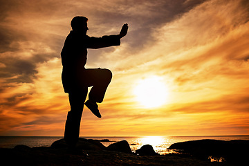 Image showing Karate, sunset and fitness with a sports man training outdoor on the beach during summer with mockup. Exercise, workout and health with the silhouette of a male athlete exercising for balance