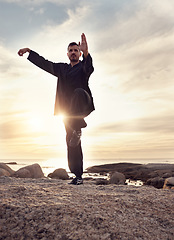 Image showing Man, tai chi and meditation while calm, mindfulness and wellness for mindfulness, balance and relax at the beach. Male meditate, training and spiritual faith outdoor at ocean during sunset in summer