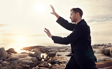 Image showing Nature, zen and tai chi, man on beach for balance and peace for mental wellness or control of body and mind. Spiritual health, fitness and meditation, energy and self care on rocks at sea in sunset.