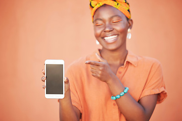 Image showing Phone screen, mockup and african woman with fashion website, sales promotion and marketing space for product placement, branding or logo. Orange wall, hand holding cellphone and a Nigeria black woman