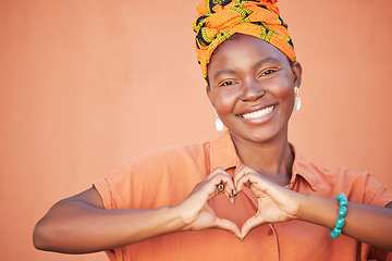 Image showing Portrait of black woman, heart hands and emoji for love, care and kindness, trust and support on orange background. Happy, smile and girl, finger shape and wellness for self care, peace and happiness