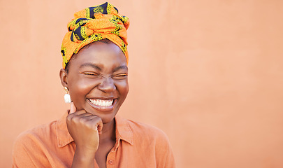 Image showing Black woman, face and smile with a turban and free space for African culture, happiness and beauty mockup on peach background. African female with Nigeria tradition fashion head scarf while laughing