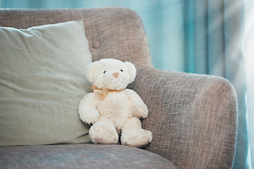 Image showing Lonely, loss and adoption with a teddy bear abandoned on a sofa in an empty living room of a home. Lost, alone and grief with a stuffed animal sitting on a couch in the lounge of a house alone