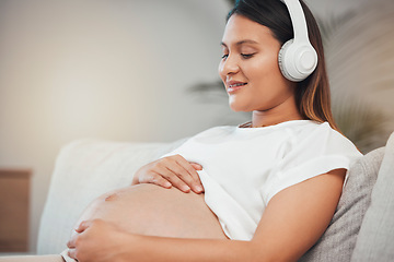 Image showing Woman, pregnant and relax while listening to calm music on sofa in healthy zen, wellness or meditation at home. Pregnant woman smile in relaxation holding tummy with headphones on living room couch