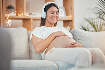 Image showing Pregnant, music and relax with a woman sitting on a sofa in their living room of her home expecting a baby. Pregnancy, wellness and stomach with a young female streaming audio alone in her apartment