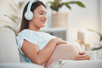 Image showing Pregnant woman, music and holding belly or bump while relaxing and bonding with her baby at home. Babies, mother touching stomach and listen to audio on headset for bond in family home