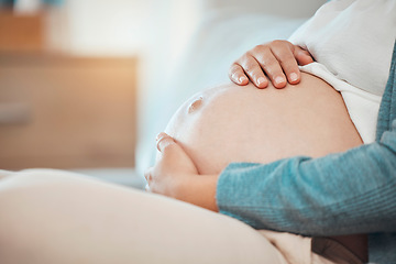 Image showing Hands, stomach and pregnant with a woman sitting in the bedroom of her home alone while touching her belly. Mother, love and baby with a female parent holding her tummy while on the bed to relax