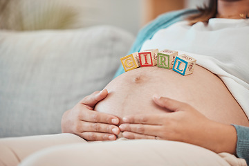 Image showing Pregnant woman, stomach and baby blocks in home for girl announcement on sofa in living room. New mother, parenthood love and childcare or pregnancy support, relax and calm mom with hands on belly