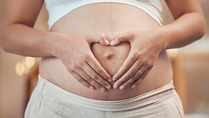 Image showing Woman, hands or heart shape on pregnant stomach in house, home living room or prenatal care clinic. Zoom, pregnancy or mother touching belly in love, care or trust of baby health, support or security