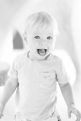 Image showing Black and white portrait of cute little infant baby boy child playing on outdoor playground. Toddler plays on school or kindergarten yard.