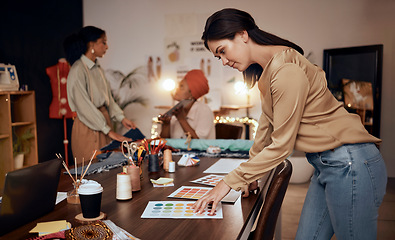 Image showing Fashion, workshop and manufacturing women at night for small business, startup production or retail management of color choice. Textile industry, clothes supplier and people at desk in team planning