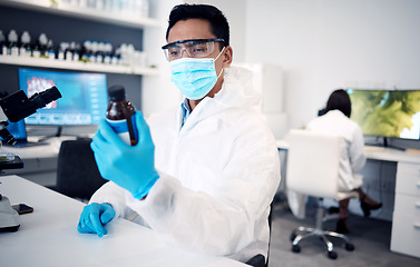 Image showing Covid, scientist and man with bottle in laboratory with cure or cough mixture. Science, research and male developing chemical, medicine or treatment, remedy or medication for flu, corona or covid 19.