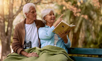 Image showing Book, search or old couple bird watching in nature for calm, relaxing or peaceful quality bonding time in New York. Love, elderly or senior woman pointing in a park with a happy old man in retirement