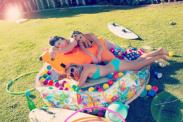 Image showing Friends, women and pool party in summer while outdoor on lawn with drinks, balls and happiness while drunk together at a celebration. Female group in bikinis in a backyard for fun with alcohol