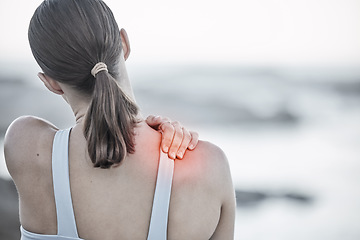 Image showing Back, pain and injury with a sports woman holding her shoulder during an exercise workout on the beach. Fitness, health and wellness with a digital CGI or overlay on a female hand outdoor in nature