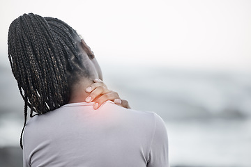 Image showing Black woman, neck and back pain on beach for fitness exercise, body wellness or sports training outdoor. African woman, body injury and shoulder muscle emergency or workout acciedent by ocean sea