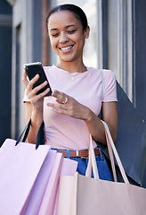 Image showing Shopping, smartphone and black woman with shopping bag at outdoor mall, retail and fashion boutique with technology and communication. Mobile phone, shop and customer, happy and check social media.