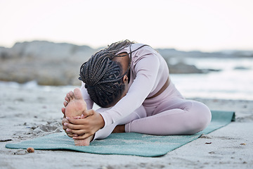 Image showing Yoga, fitness and beach with a black woman stretching on an exercise mat for health or wellness in nature. Workout, training and balance with a female yogi doing a warm up by the sea or ocean