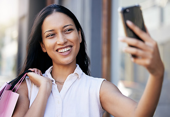 Image showing Woman, phone selfie and luxury shopping, social media and picture outdoor in Miami, shopping bag and happy smile. Young female, mobile smartphone and photo outside a retail store or shopping mall