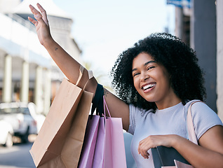 Image showing Black woman while shopping with smile and shopping bag, wave in outdoor mall, hail taxi or transport in Rome, retail and customer. Young shopper in city, happy with designer brand and discount sale.