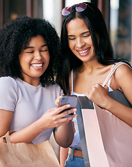 Image showing Shopping, friends and women with phone in the mall enjoying freedom, quality time and weekend together. Shopping bags, smartphone and young girls laughing at meme online, social media and internet