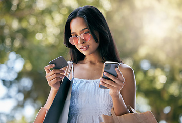 Image showing Woman, credit card and smartphone for ecommerce, outdoor or online shopping bags. Young Latino female, customer or lady shopper with phone, purchase clothes or spending for expensive products or sale