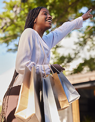 Image showing Black woman, shopping bags and outdoor on city street while happy and hailing for a taxi or cab to travel on consumer journey. African female with hand up for transport with a smile after retail sale