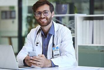 Image showing Doctor, desk and phone with smile for texting, communication or chatting and good connection at hospital. Happy man healthcare or medical professional smiling for telecommunication service at clinic