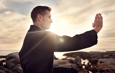 Image showing Karate man, martial arts and tai chi training to fight at beach against cloudy sunset sky for focus, power and energy outdoor. Male fighter ready for sports, fighting and exercise for fitness at sea