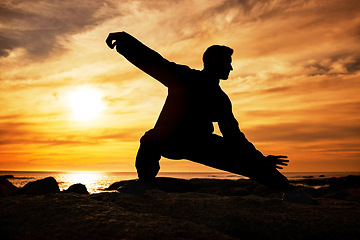 Image showing Karate man, silhouette and tai chi with sunset sky on beach horizon for martial arts, taekwondo or fight exercise, training or practice. Art deco of athlete at sea for nature workout and fitness