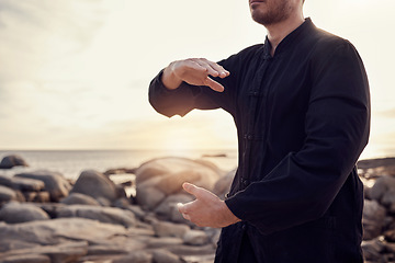 Image showing Beach, peace and tai chi, man in nature for balance and peace for mental wellness or control of body and mind. Spiritual health, fitness and meditation, energy and self care on rocks at sea in sunset