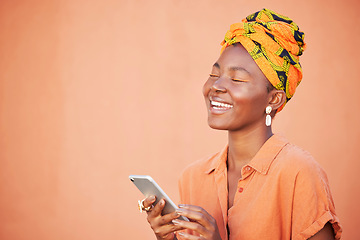 Image showing Face, phone and black woman on social media in studio, texting or internet browsing on an orange mockup background. Comic, smile and happy female with mobile smartphone laughing at funny joke or meme