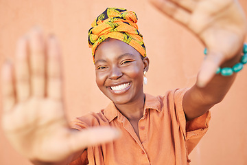 Image showing Fashion black woman, face or framing hands on orange wall background in city for profile picture, Congo branding or clothing advertising. Portrait, smile or happy model in photography pov with turban