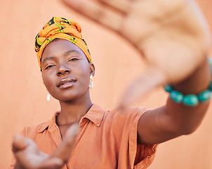 Image showing Black woman, face portrait and hands frame for fashion aesthetic, african culture and turban in studio with orange background. Nigeria, cosmetics makeup and traditional head scarf or playful gesture