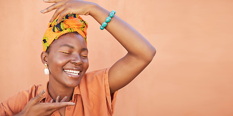 Image showing African, fashion and face of black woman on orange wall background with natural beauty, makeup and smile. Culture, hands and girl in Nigeria with designer jewelry, exotic cosmetics and head scarf