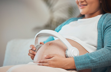 Image showing Pregnant woman, headphones and listening to music or podcast for zen, calm and peace with hands on stomach for kick and moving. Female with wireless audio to relax and connect during pregnancy