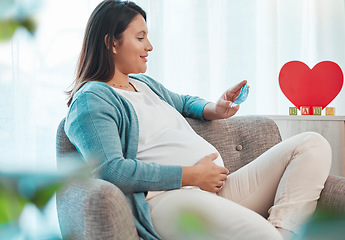 Image showing Pregnant woman, ultrasound and mother on sofa in home looking at picture. Pregnancy, sonography and happy female in house with photograph, sonogram and love, care and affection for baby in stomach.